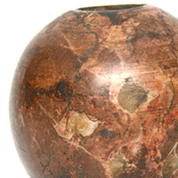 This is a variegated red stone, globular mace head. Similar to the piriform mace head, this style was commonly used in Mesopotamia around 2450-1900 BC. Its use was cut short due to the introduction of helmets and body armor early in these areas. These type mace heads would have been attached to a wooden shaft and used as a weapon to strike an enemy.<a class="macecolorred" href="../images/maces/mesopotamian.jpg">Click Here to see a larger version of this image.</a>